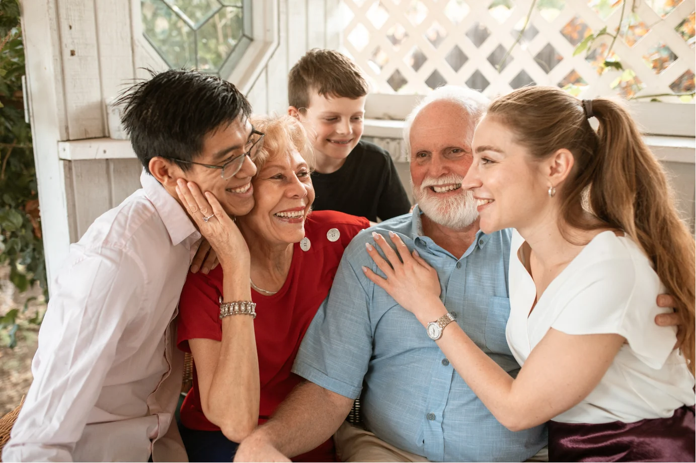 A multigenerational family smiling together in a bright, welcoming home